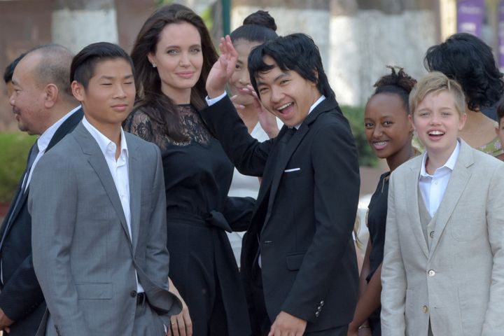  Angelina Jolie and her children gesture to media in front of the royal residence for a meeting with Cambodian King Norodom Sihamoni in Siem Reap on Feb. 18.