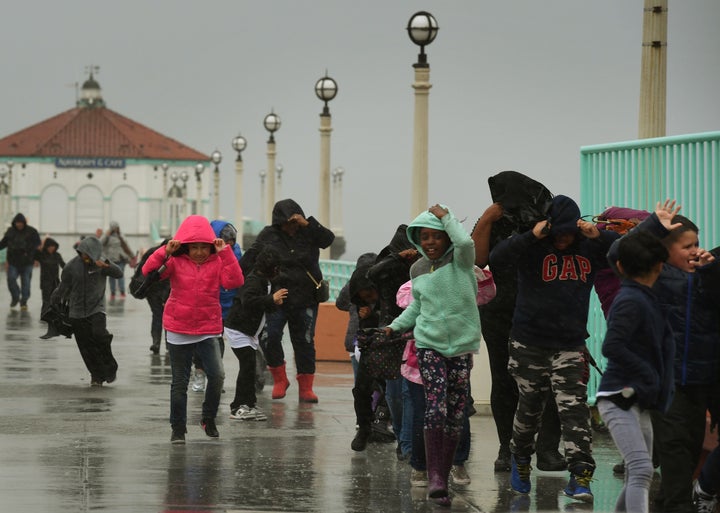 Schoolchildren race back to their bus after getting caught in heavy rain during a school excursion in Los Angeles on Friday.