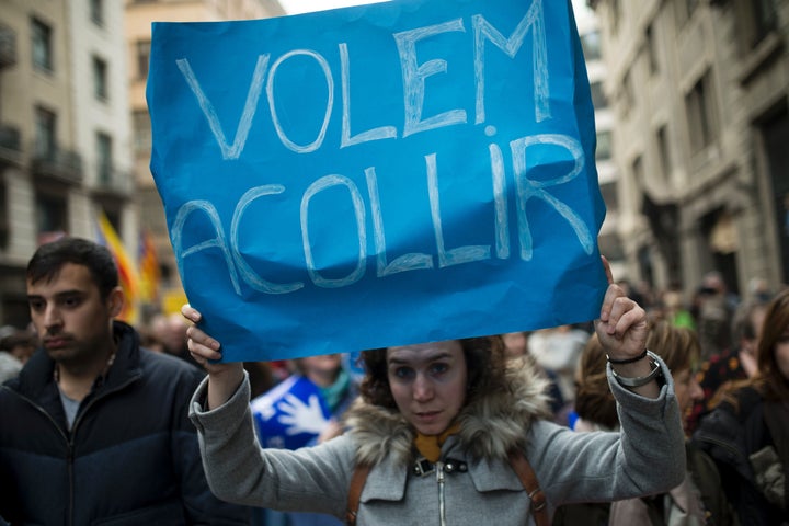 A woman holds a placard reading "We want to welcome" during a demonstration to demand to welcome refugees in Barcelona.