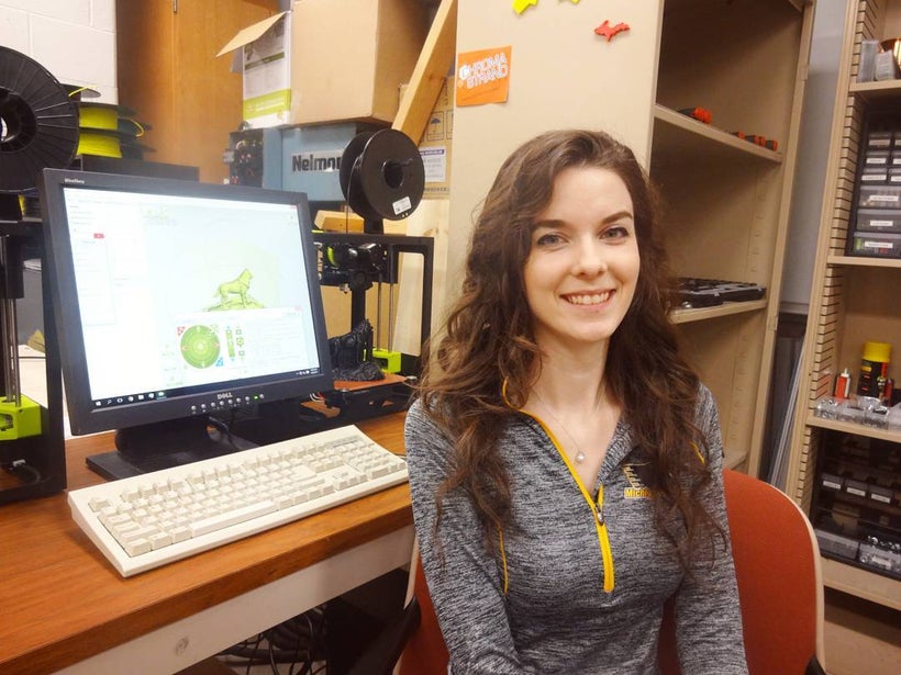 Emily Petersen, a co-author on the study, in a lab with open source Lulzbot Mini 3-D printers being used to print husky statu