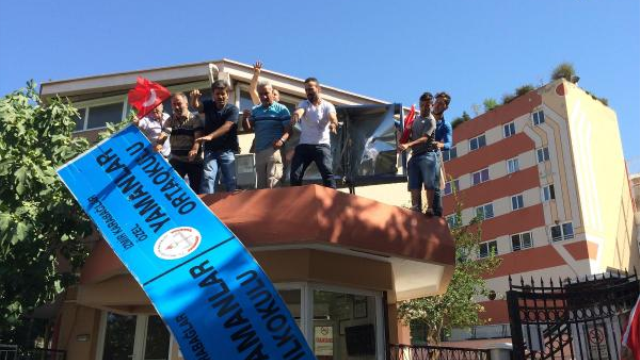 Erdogan supporters dismantling the sign of Gulen-inspired Yamanlar science school in Izmir, Turkey (23 July 2016) after the school was ordered shut down by the authorities.