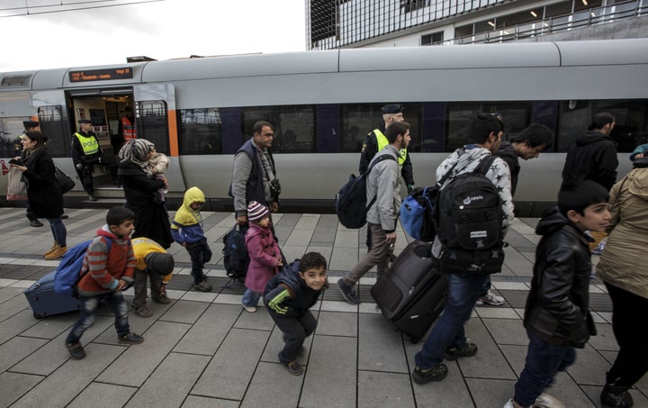 Policemen and a group of migrants stand on the platform at the Swedish end of the bridge between Sweden and Denmark in Malmo, Sweden, on November 12, 2015.