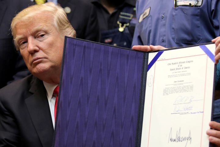 President Donald Trump shows Resolution 38, which nullifies the stream protection rule, after signing it at the White House on Feb. 16.