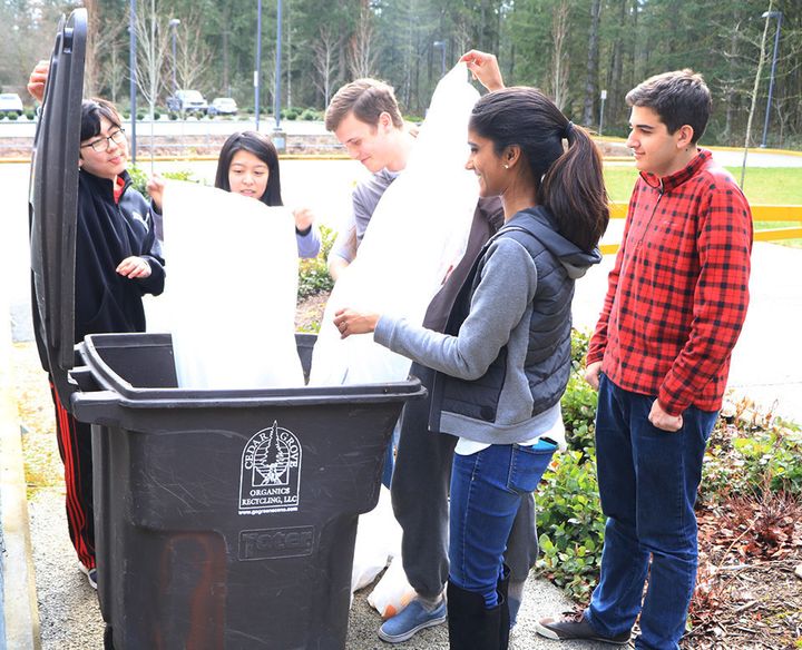 A group of students at Tesla STEM High School records how much waste has been saved through the recycling and composting programs.