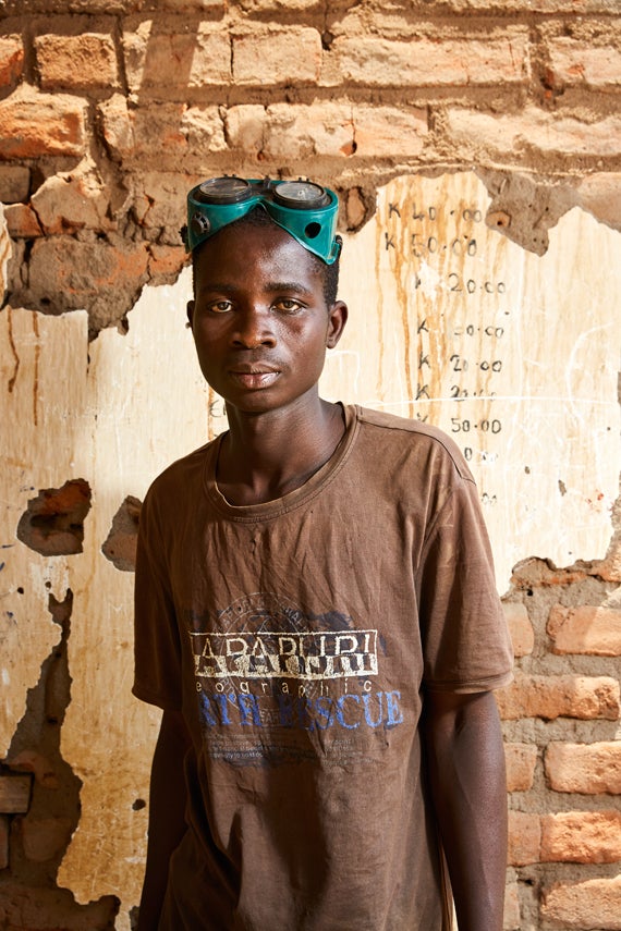 Raphael Bosa, 21 years old, wearing a pair of welding goggles, stands in the welding workshop he runs with his friend Geoffre