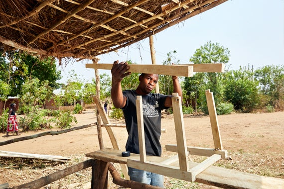 Blessings Kamanga, 23 years old, works on a chair, at his carpentry stall near Luchenza, southern Malawi. Blessings graduated
