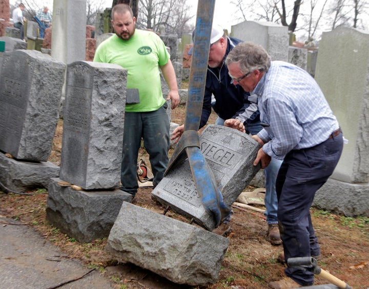 Spencer Pensoneau, Ron Klump and Philip Weiss of Weiss and Rosenbloom Monument company, work to right toppled Jewish headstones.