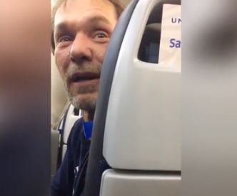 A man was escorted off a flight in front of a cheering crowd following accusations that he was being 'racist' towards other passengers.