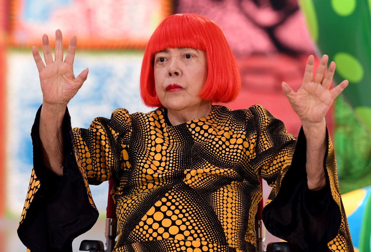 Japanese artist Yayoi Kusama waves at a photo session during a press preview in 2017.