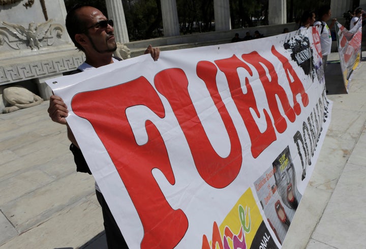 A Mexican deportee holds a banner as he protests against U.S. President Donald Trump's foreign policy, at the Benito Juarez H