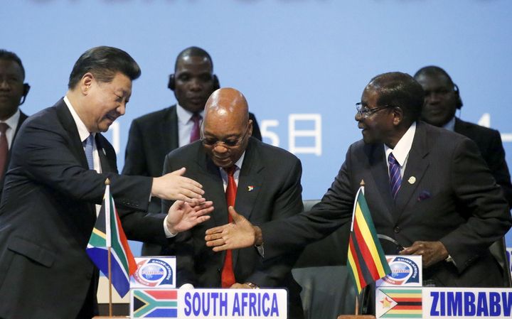 China's President Xi Jinping shakes hands with Zimbabwe's President Robert Mugabe while South Africa's President Jacob Zuma looks on during the Forum on China-Africa Cooperation in Johannesburg, Dec. 4, 2015.
