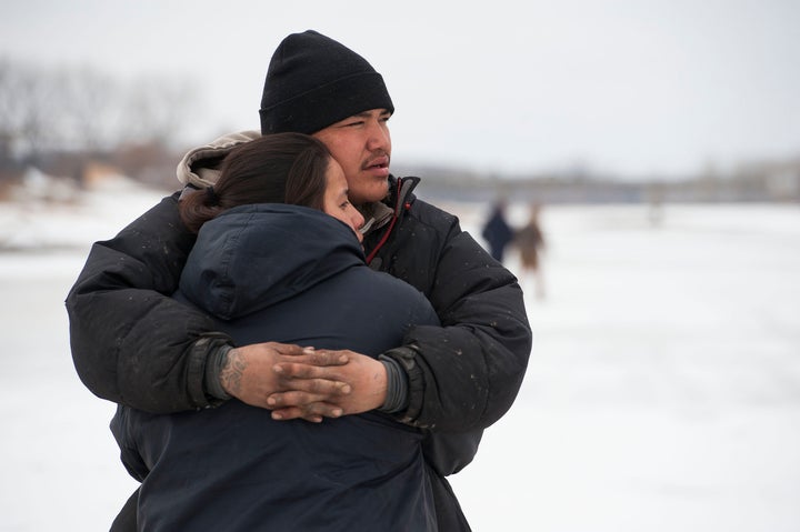 Ramona Three Legs, 24, and Oscar High Elk, 26, embrace after abandoning their possessions to avoid a police raid on the Oceti Sakowin camp in North Dakota on Thursday.