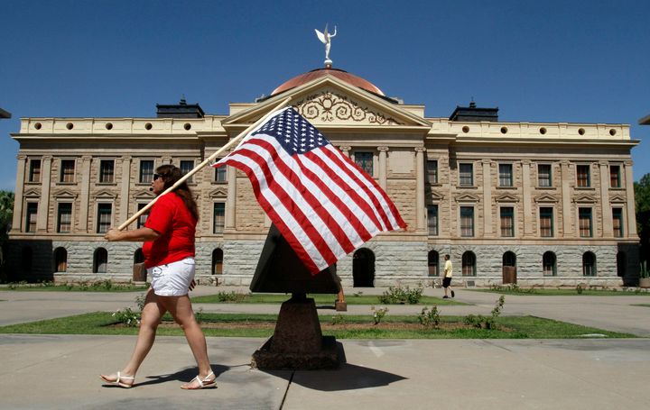 A protester marches around the Arizona State Capitol's grounds in 2012 after the Supreme Court upheld a key part of Arizona's crackdown on illegal immigrants.