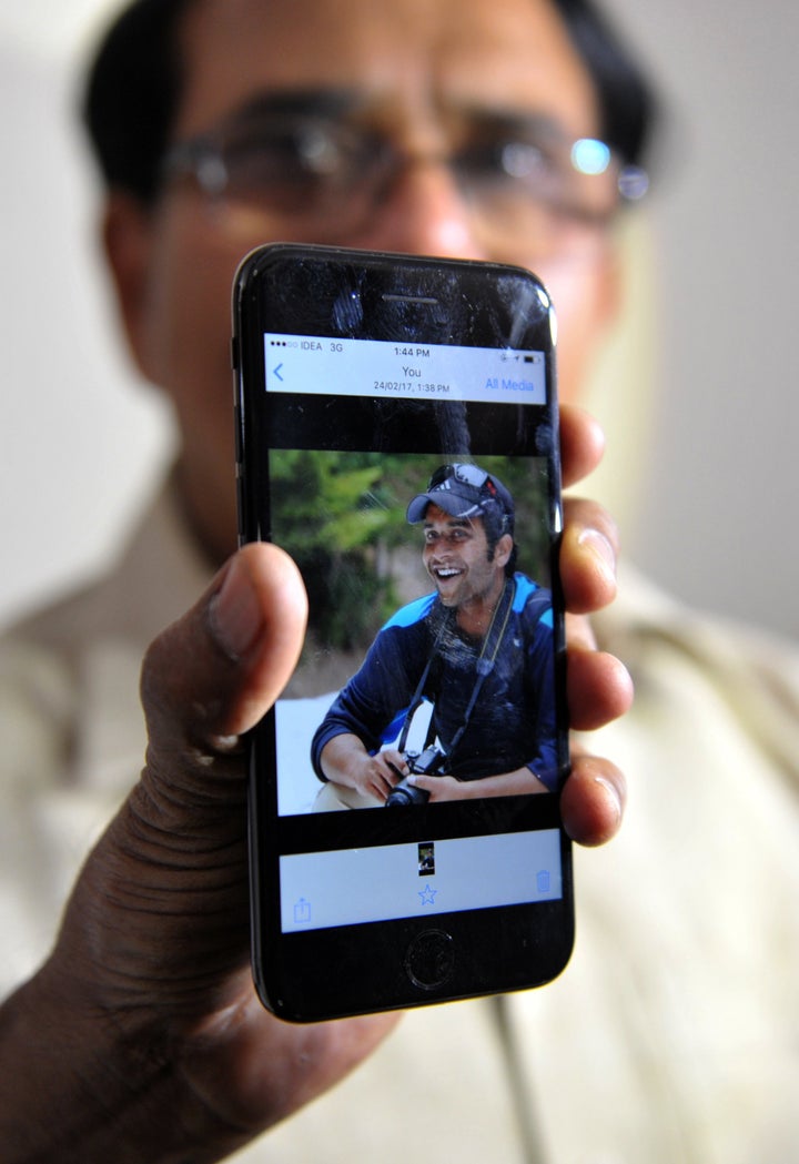 Alok Madasani's father holds up a smartphone with an image of his son at his residence in Hyderabad on Feb. 24, 2017.