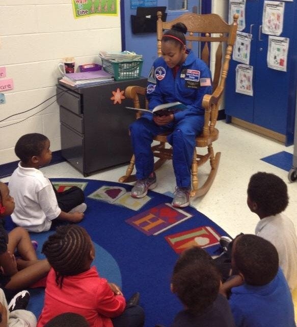 Taylor Richardson reads to a group of children.