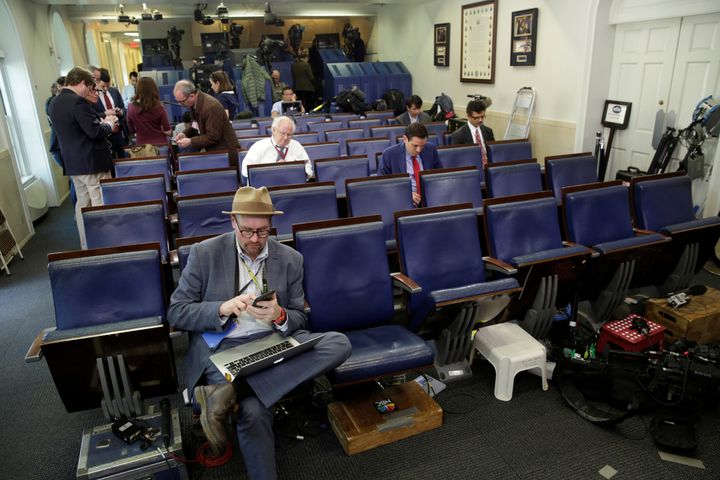 Glenn Thrush (L), chief White House political correspondent for the New York Times, works in the briefing room after being excluded from a press briefing