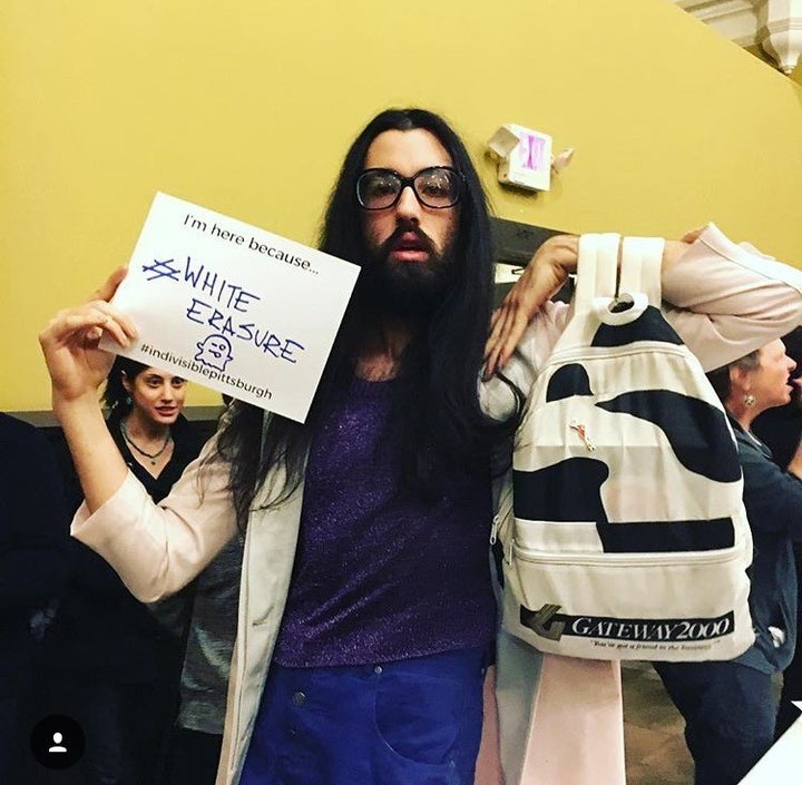 Intersectional femme artist and activist Mario Josephine holds a sign that reads “I’m here because #WhiteErasure.”