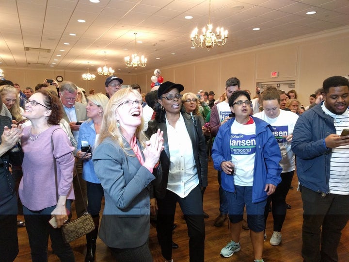 Democrat Stephanie Hansen, surrounded by volunteers, watches election results showing her victory in Saturday's special state Senate election.