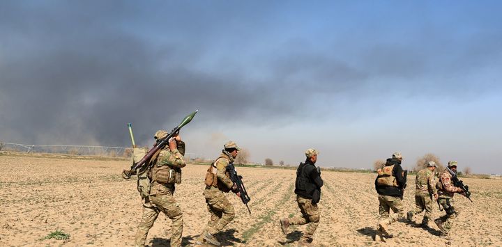 <p>Rapid response teams cross farmland in the battle to regain Mosul.</p>