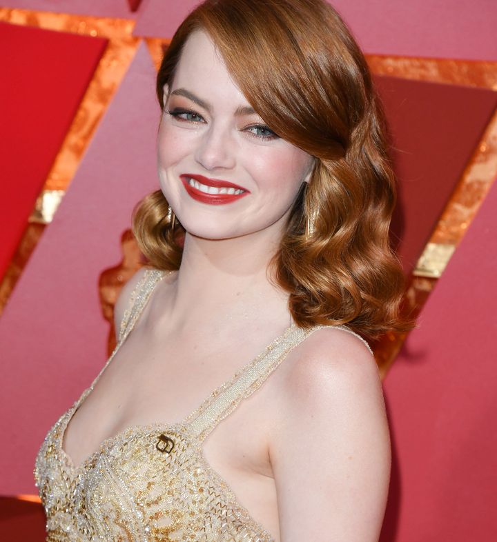 Oscar-winner Emma Stone flaunts her gold Planned Parenthood pin at Sunday night's ceremony. 