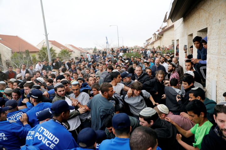Pro-settlement activists scuffle with Israeli policemen.