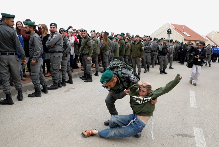 Israeli forces evict residents from several homes in the Israeli settlement of Ofra.