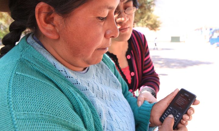 <p>Regina Quillahuaman from Peru shows a mobile phone message confirming that her Bim account is up and running. </p>
