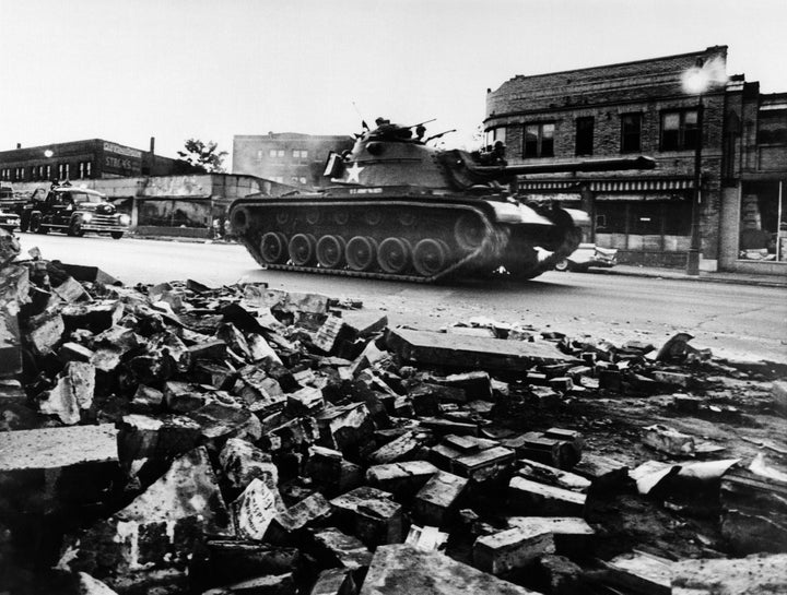 A tank patrols a devastated Detroit street on July 25, 1967.