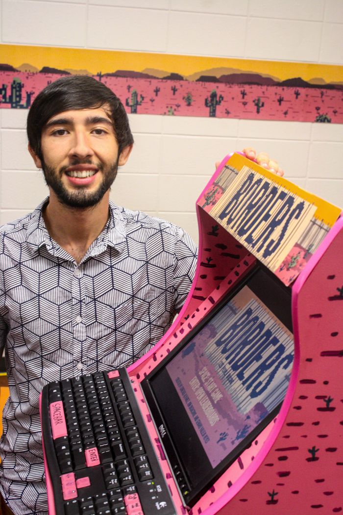Gonzalo Alvarez poses with his art installation and video game "Borders." 