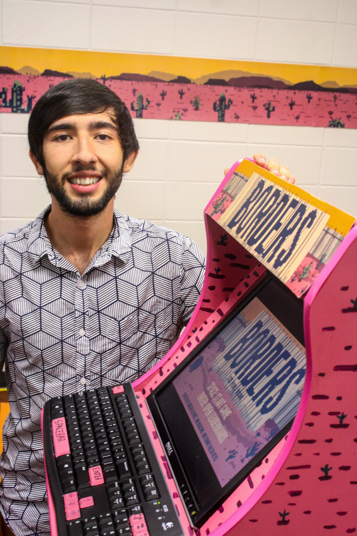 Gonzalo Alvarez poses with his art installation and video game "Borders."