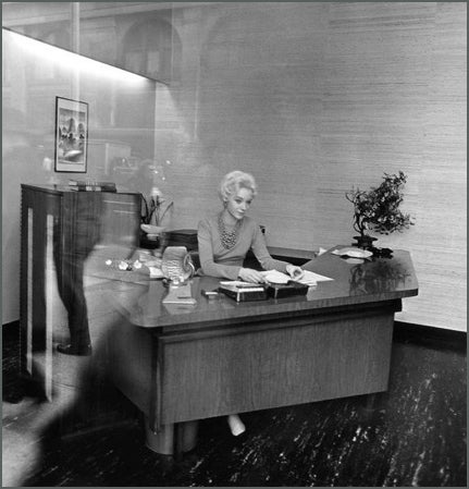 Blonde receptionist behind a picture window, N.Y.C., 1962.