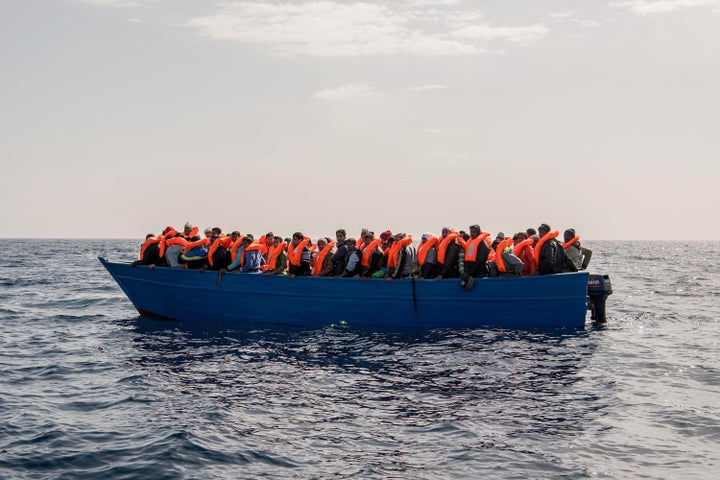 Migrants and refugees are assisted by members of the Spanish NGO Proactiva Open Arms as they crowd on board of a wooden boat sailing out of control off the Libyan coast. 