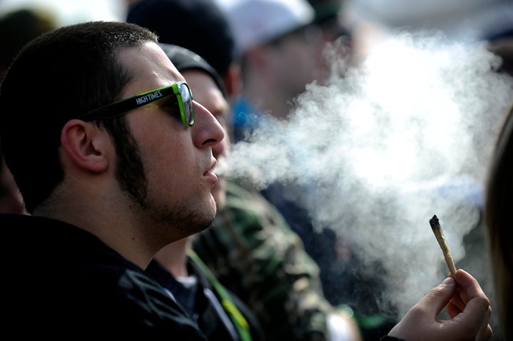 A man exhales marijuana smoke during the High Times Cannabis Cup at the Denver Mart in Denver, Colorado on April 19, 2015.