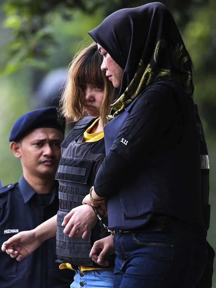 Vietnamese national Doan Thi Huong, center, 28, is escorted with a heavy police presence after a court appearance with Indone