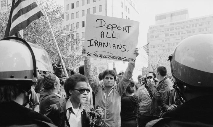A man holding a sign that reads "deport all Iranians" and "get the hell out of my country" during a protest of the Iran hostage crisis in Washington, D.C. in 1979.