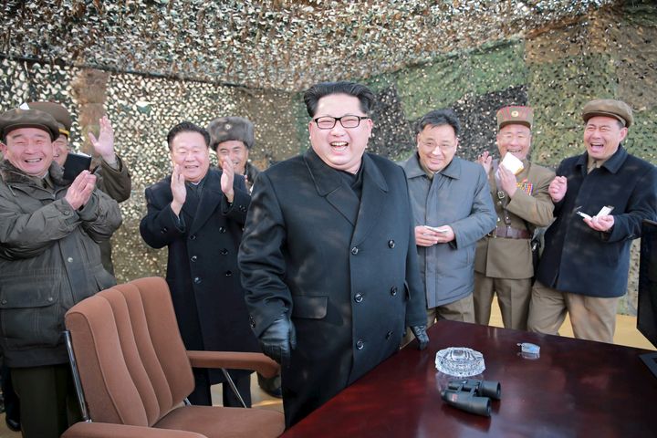 North Korean leader Kim Jong Un celebrates as he guides a test fire of a new multiple launch rocket system.