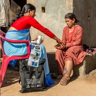 An FCHV in Nepal provides information and treatment to a woman with lymphatic filariasis, a type of NTD. 