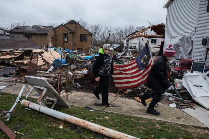 Ryan Chamberlain, 11, right, and Jacob Vogel, 12, on Wednesday, March 1, 2017 pass by the house of Jerry Nanouski, which was damaged in the tornado in Naplate, Ill.