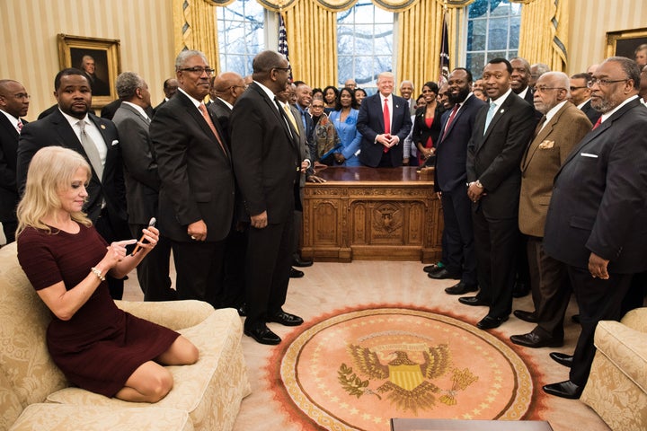 Kellyanne Conway checks her phone after taking a photo in the Oval Office. Some took issue with the photo, calling her pose t