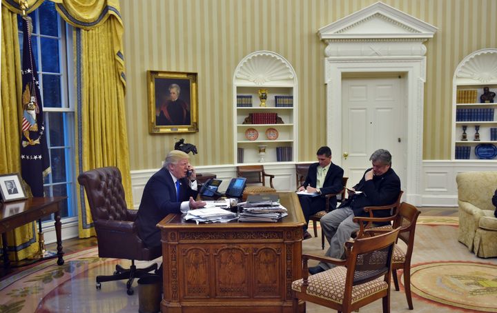 President Donald Trump with Chief Strategist Steve Bannon (R) and former National Security Advisor Michael Flynn in the Oval Office of the White House on January 28, 2017, in Washington, DC.