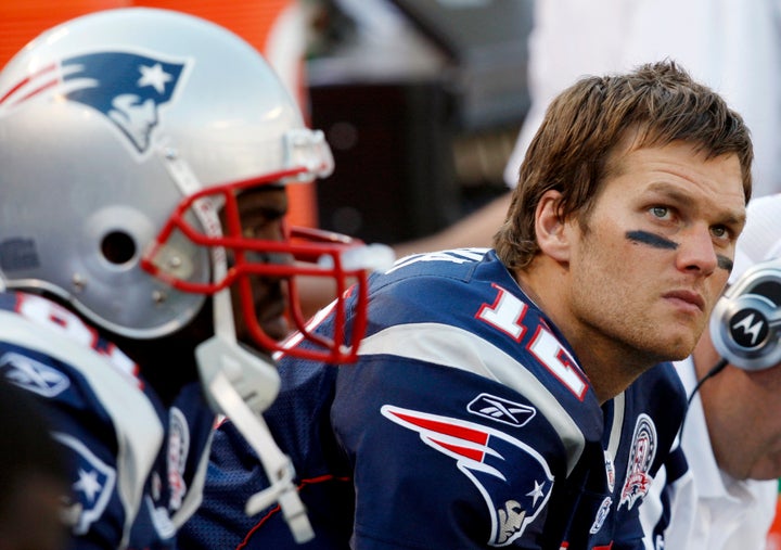 Tom Brady (R) and receiver Randy Moss sit on the bench late in the fourth quarter of their loss to the New York Jets in their NFL football game in East Rutherford, New Jersey, September 20, 2009.