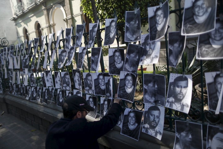 A man hangs images of murdered journalists outside the Government of Veracruz building in Mexico City, Feb. 11, 2016. Mexico is considered to be the deadliest country for journalists in the western hemisphere.