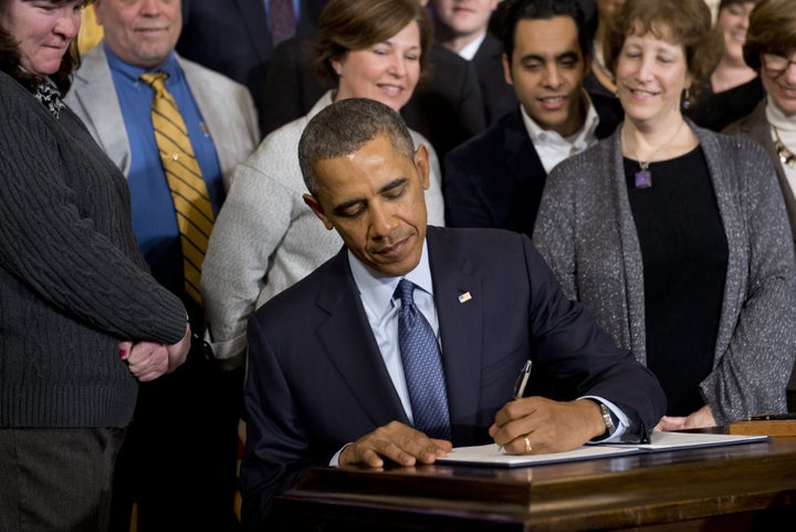 President Barack Obama signs a presidential memorandum directing the labor secretary to update overtime regulations on March 13, 2014.