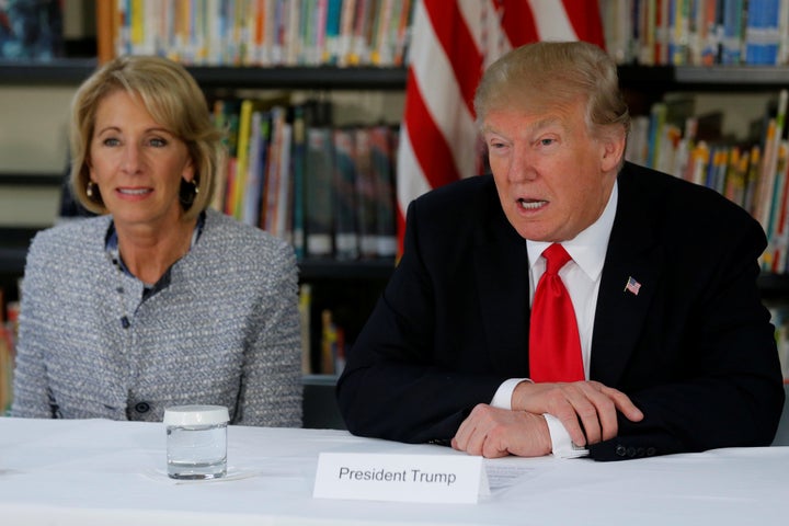 U.S. President Donald Trump (R) and Education Secretary Betsy DeVos (L) meet with parents and teachers at Saint Andrew Catholic School in Orlando, Florida, on Friday.