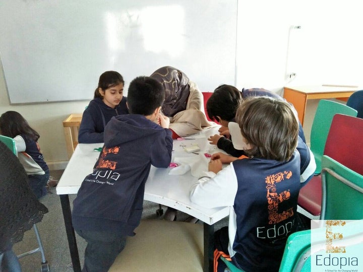 Students gathered around their teacher during the day.