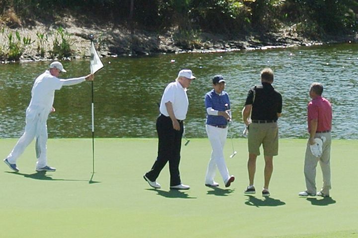 Trump (2nd L) and Japan's Prime Minister Shinzo Abe (C) playing golf in Florida on February 11