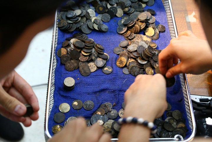 The coins, which altogether ended up weighing around 11 pounds, are seen being counted after their removal on Monday.