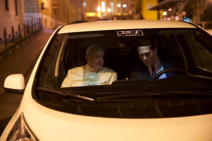 Pope Francis checks out the features of his new electric Nissan Leaf.