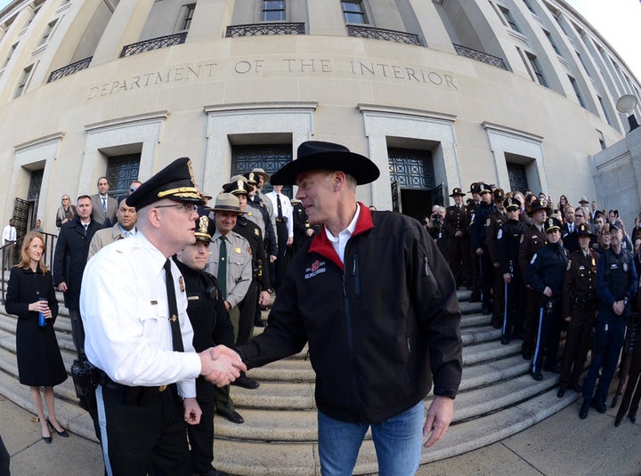 Interior Secretary Ryan Zinke, right, greets employees after riding in on horseback with a U.S. Park Police mounted unit to r