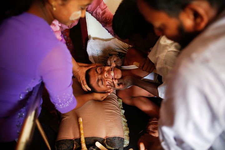 A 16-year-old with severe symptoms of rabies is comforted by family members in Myanmar, April 29, 2013.